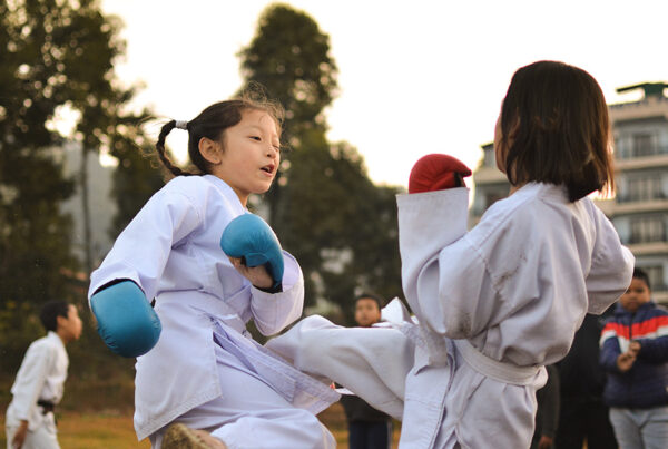 Two children sparring with equipment on