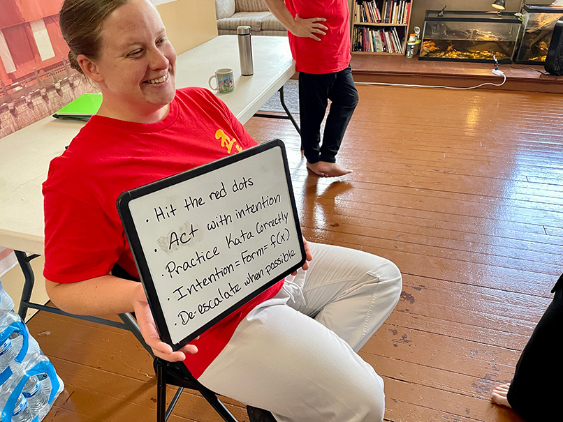 A photo of Ms. Maddie with a whiteboard recapping the training camp