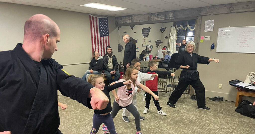 Karate instructors lead students in punching techniques