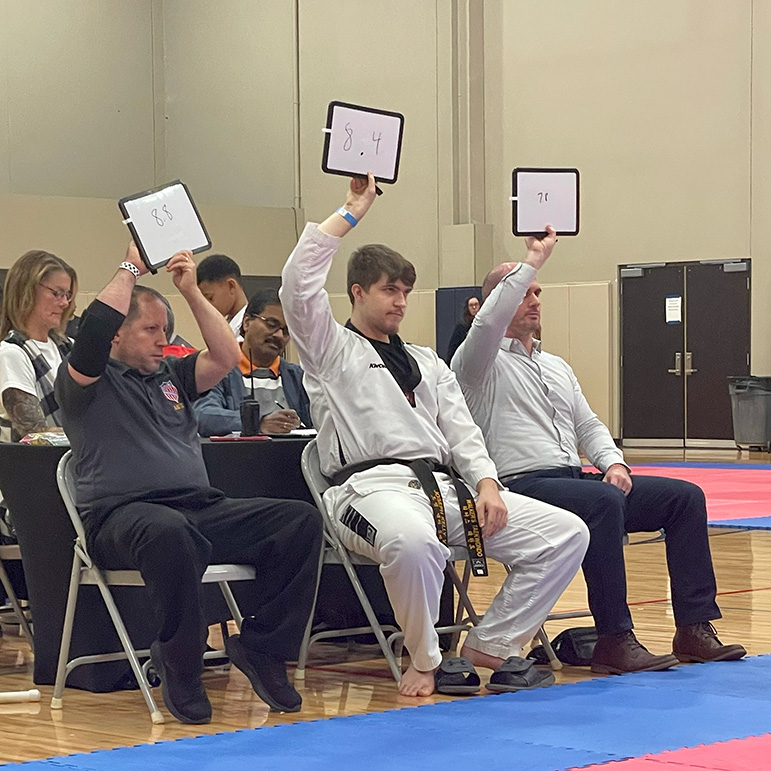 Adam Bockler sits on a judges panel for forms at the 2024 Midwest Open